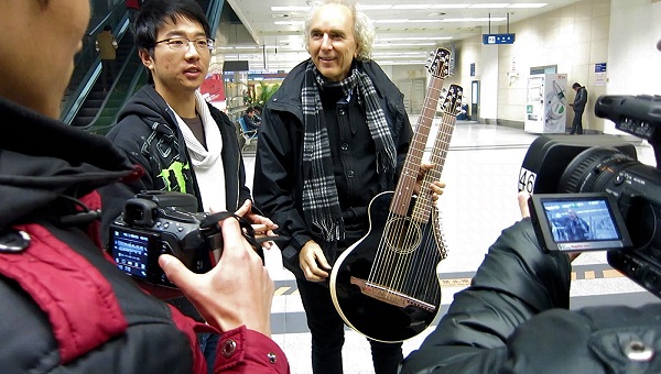 John Doan and his harp guitar greeted in Xi'an China by reporters