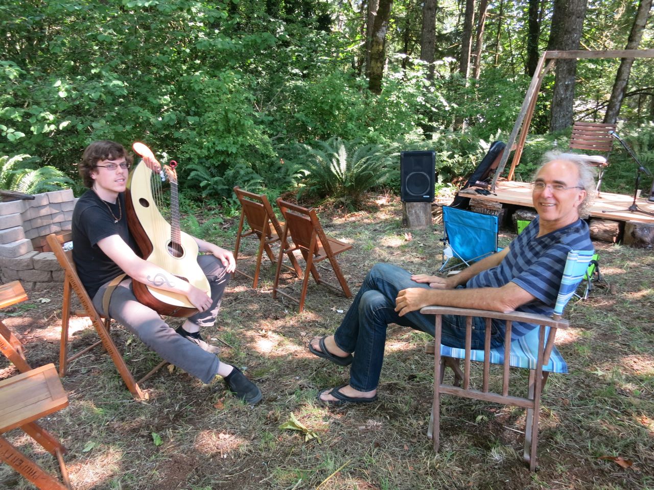 John gives a private lesson to Adrian in the woods with the harp guitar.