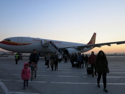 John Doan Arrives Beijing walking off the airplane at the airport.